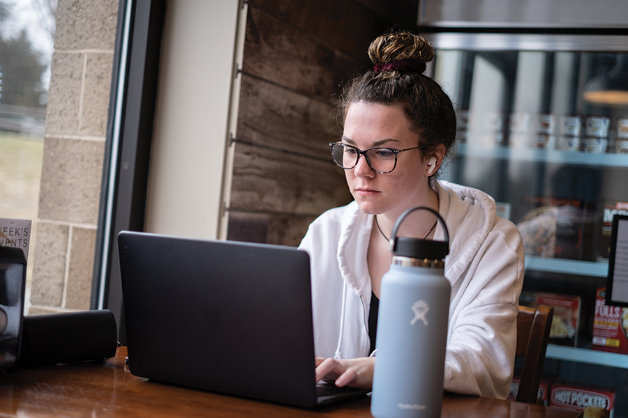 Student working on laptop inside the Coffee Shop