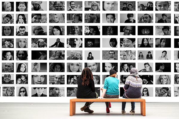 students sitting in front of a wall of black and white portraits