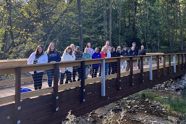 students pose on bridge