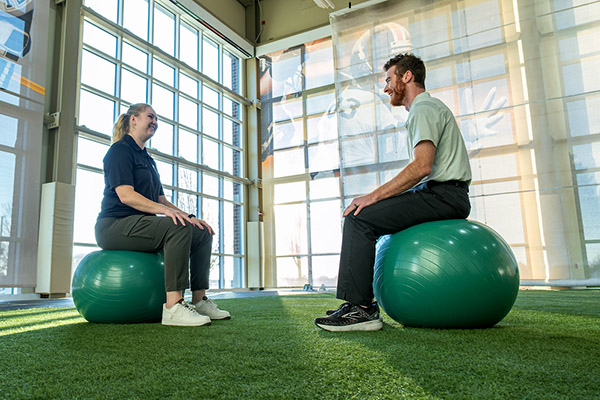 Two people sitting on exercise balls