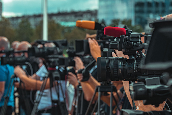 Multiple cameras on tripods facing left.