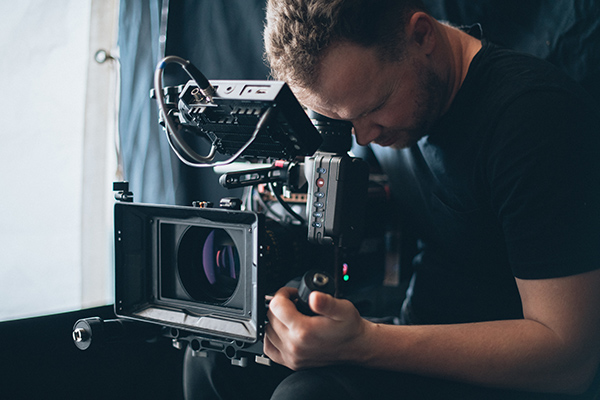 Film producer looking through camera