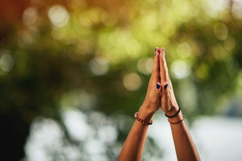 hands with palms together reaching for sky