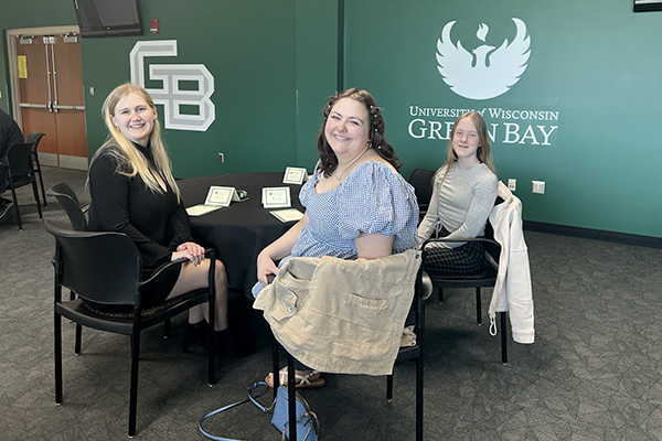Three students around a table in a campus conference room