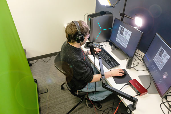 Student designs video game on dual monitors in media room