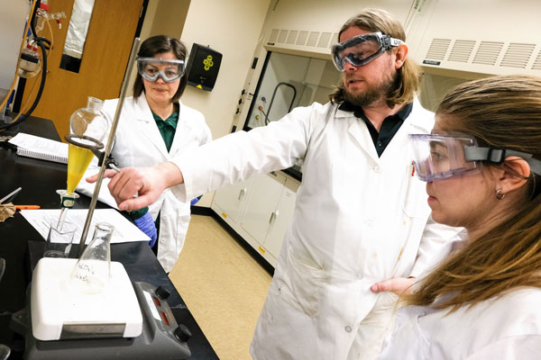 Professor and students in chemistry lab