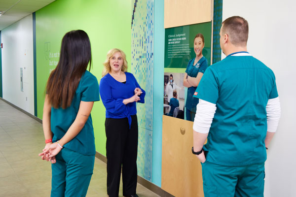 Two students talk with professor