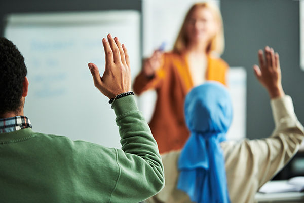 Teacher in class with adult ethnic pupils