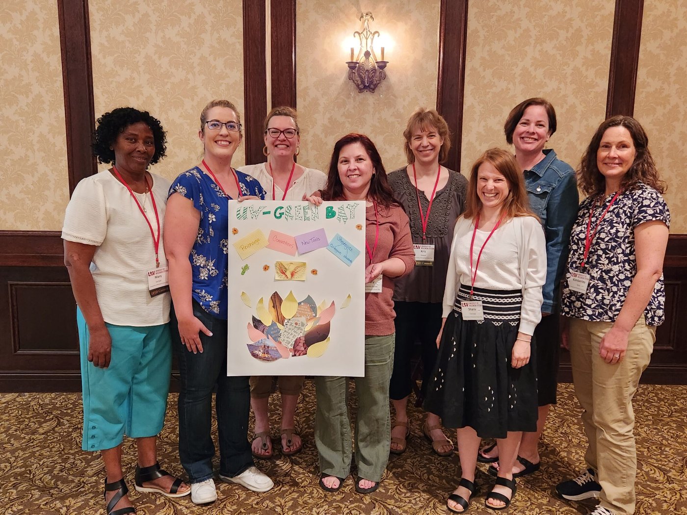 group of smiling instructors holding a poster