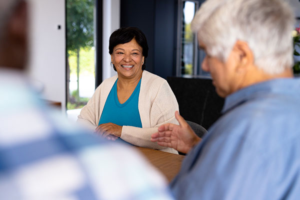 smiling bipoc senior woman talking at dining table