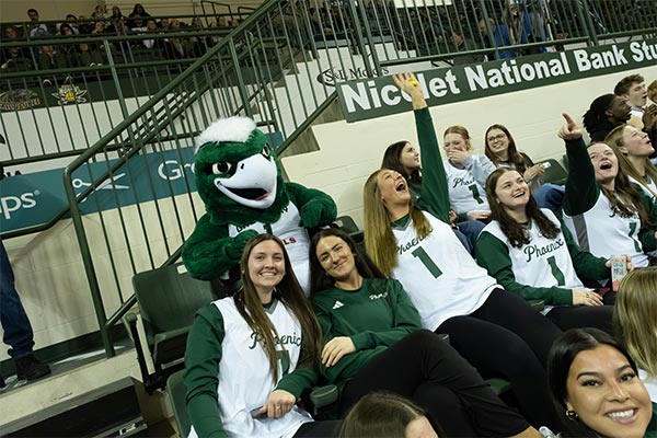 Students in the crowd with the UWGB Phlash mascot.